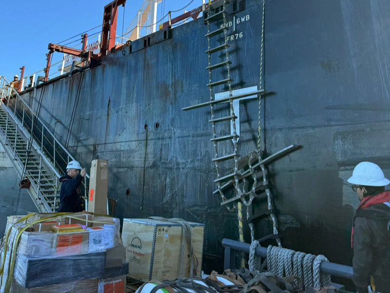 Workers next to a large industrial vessel