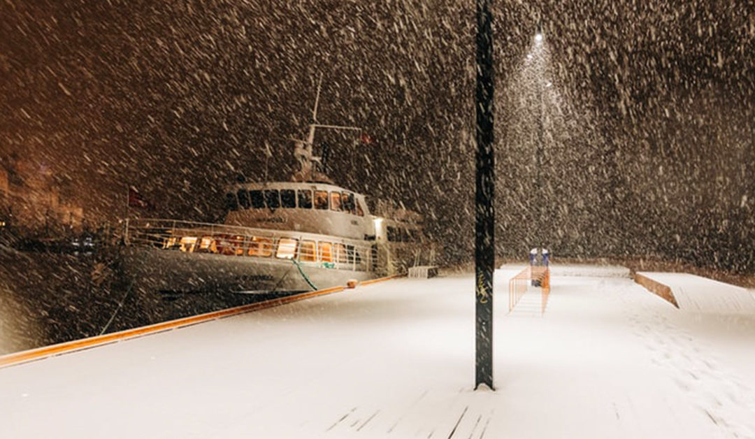 Boat anchored at the dock as the snow falls